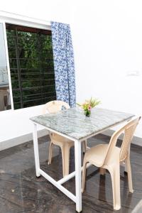 a white table and chairs on a porch with a window at BrightMoon_Homestay in Pondicherry