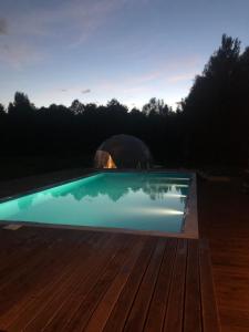 a swimming pool with a yurt in the background at Glamping Stodoła Dome in Ściegny
