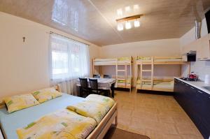 a room with bunk beds and a kitchen with a table at Agroturystyka Nad Tanwią in Budziarze
