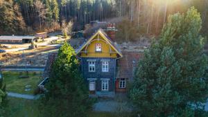 a house with a yellow roof in the middle of trees at Bahnhof Paulinzella mit Sauna in Königsee