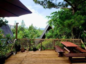 um deque de madeira com dois bancos e um guarda-chuva em LOGIN OKINAWA -plants- em Onna