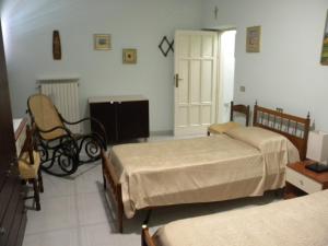 a room with two beds and a chair in it at La Casa di Prisco in Grassano