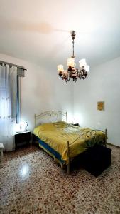 a bedroom with a bed and a chandelier at Casetta Nonna Giacomina 1camera da letto e soggiorno con angolo cottura in Valderice