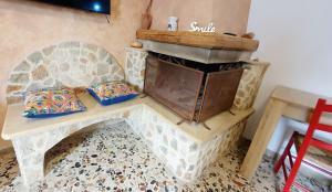 a stone fireplace in a room with a table at Casetta Nonna Giacomina 1camera da letto e soggiorno con angolo cottura in Valderice