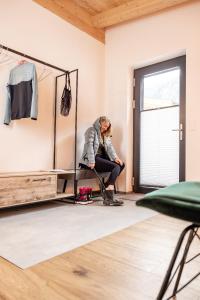 a woman sitting in front of a dressing room at Fichtenlodge Stubaital in Neustift im Stubaital