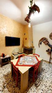 a dining room with a table and chairs and a tv at Casetta Nonna Giacomina 1camera da letto e soggiorno con angolo cottura in Valderice