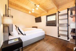 a bedroom with a bed and a desk and a window at Fichtenlodge Stubaital in Neustift im Stubaital