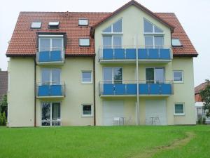 a house with blue balconies and chairs in a yard at Gasthof zur Sonne in Stuttgart