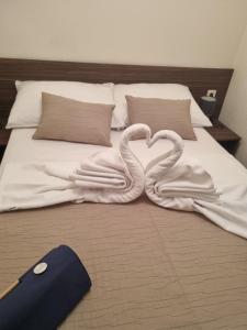 Zwei Schwäne bilden ein Herz auf einem Bett in der Unterkunft Mobile Home Palma in Drage