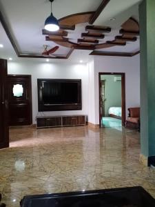 a living room with a flat screen tv and a couch at Homie Sweetie in Morong