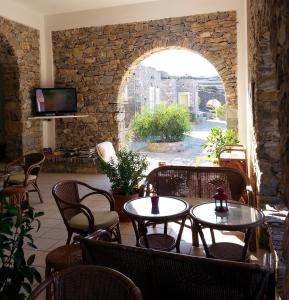 een restaurant met tafels en stoelen en een stenen muur bij Archipelagos Boutique Hotel in Skhoinoussa