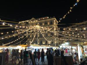 un groupe de personnes se promenant dans un marché la nuit dans l'établissement AliceA apartment in Siracusa, à Syracuse