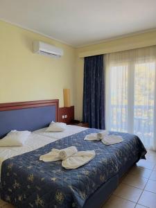 a hotel room with a bed with towels on it at Theodorou Beach Hotel Apartments in Kos