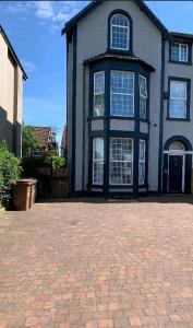 a large house with a brick driveway in front of it at Beach house in Crosby