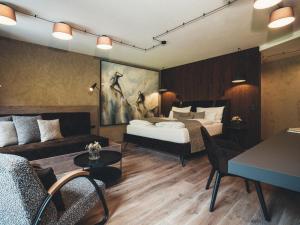 pokój hotelowy z łóżkiem i kanapą w obiekcie Hotel Tirolerhof 4 Sterne Superior w mieście Tux