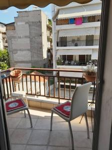 a balcony with chairs and a view of a building at Lititsia apartment in Thessaloniki