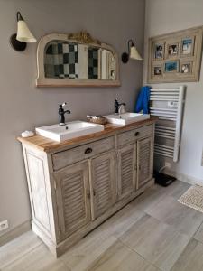 een badkamer met 2 wastafels en een spiegel bij Bâtisse XVIII ème, dans enceinte d'un château. in Brains-sur-Gée