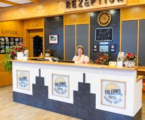 a woman standing behind a counter at a restaurant at Erlebnishotel Kärnten-Mölltal 3 Stern Superior in Obervellach