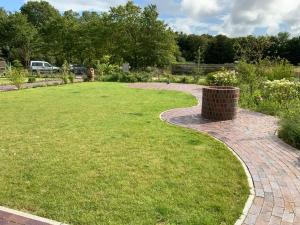 Una pasarela de ladrillo en un jardín con un cubo de basura en Austernfischer, en Büsum