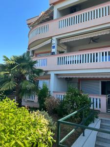 a building with a palm tree in front of it at Apartments Gojević in Crikvenica