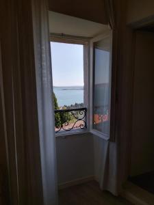 een raam in een kamer met uitzicht op de oceaan bij Belvedere Hotel & Villa in Toscolano Maderno