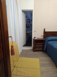 een slaapkamer met een gele stoel en een bed bij Belvedere Hotel & Villa in Toscolano Maderno
