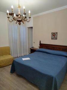 a bedroom with a blue bed and a chandelier at Belvedere Hotel & Villa in Toscolano Maderno