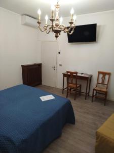 een slaapkamer met een bed, een tafel en een kroonluchter bij Belvedere Hotel & Villa in Toscolano Maderno