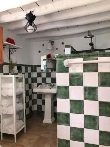 y baño con lavabo y paredes de azulejos verdes y blancos. en Las casillas de la Villa: SOLEÁ, en Montefrío