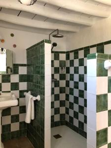 ein Bad mit einer schwarz-weiß karierten Wand in der Unterkunft Las casillas de la Villa: SOLEÁ in Montefrío