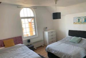 a bedroom with two beds and a window at Beach house in Crosby