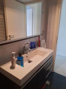 ein Waschbecken mit Spiegel und blauer Brille in der Unterkunft Lititsia apartment in Thessaloniki