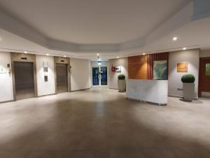 a large empty room with a lobby with two potted plants at Studio in Remraam in Dubai