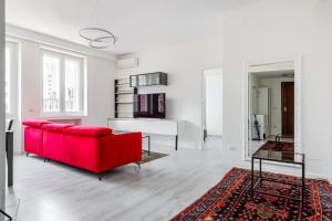 a living room with a red couch and a table at Garibaldi & Gae Aulenti Modern Apt with Private Parking! in Milan