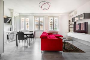 a living room with a red couch and a table at Garibaldi & Gae Aulenti Modern Apt with Private Parking! in Milan