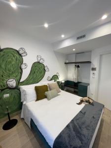 a bedroom with a large bed with a painting on the wall at Namuri Luxury Rooms in Taormina