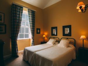 a bedroom with two beds and a window at Hotel Rural La Casa Amarilla in Los Silos