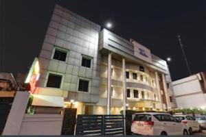 een gebouw waar 's nachts auto's voor geparkeerd staan bij SHELTER HOTEL in Lucknow