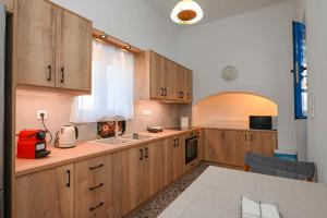 kuchnia z drewnianymi szafkami i czerwonym urządzeniem w obiekcie Η όμορφη Κώμη - Beautiful Komi spacious apartment w mieście Kómi +4 zdjęcia
