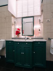 baño verde con lavabo y ventana en Hotel Rural La Casa Amarilla, en Los Silos