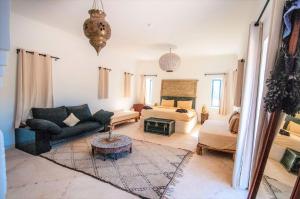 un soggiorno con divano e letto di SA FONDA a Tameslouht