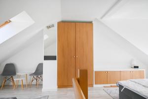 kuchnia z drewnianą szafką i krzesłami w obiekcie Komfortowy apartament dwupoziomowy w cichej okolicy w Pobierowie