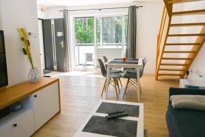 salon ze stołem i krzesłami oraz schodami w obiekcie Komfortowy apartament dwupoziomowy w cichej okolicy w Pobierowie