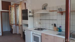 a kitchen with a stove and a white tiled wall at Ai Boschi in Ozzano dell'Emilia