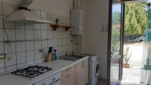 a kitchen with a stove and a washing machine at Ai Boschi in Ozzano dell'Emilia