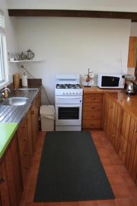 a kitchen with a white stove and a sink at Ahstyk Cottage in Burnt Pine