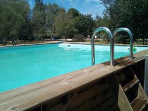 a swimming pool with blue water and metal rails at Tiny house ocean in Naujac-sur-Mer