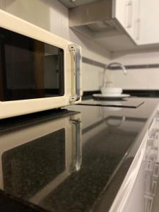 un horno microondas en la parte superior de una barra de cocina en Hostal Abami II, en Madrid