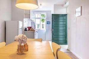 comedor con mesa de madera y puerta verde en CASA DA ROCHINHA en Funchal