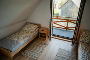 a small bedroom with a bed and a balcony at Domki przy Alei in Krasnobród